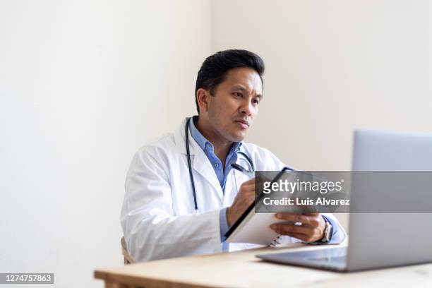 doctor having a video call with patient and making notes - special screening of wont you be my neighbor fotografías e imágenes de stock