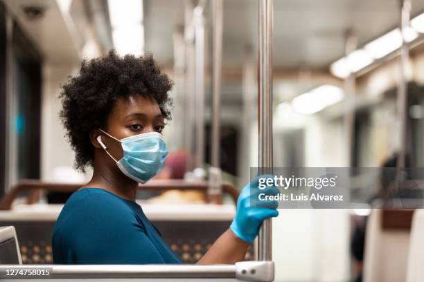 woman commuting in a train with safety during pandemic - commuter mask stock pictures, royalty-free photos & images