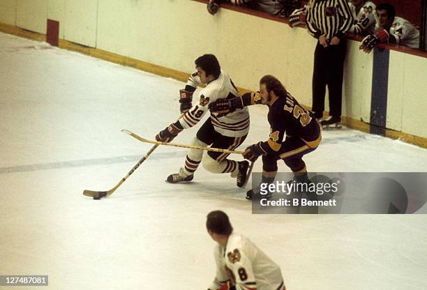Dale Tallon of the Chicago Blackhawks skates with the puck as Don Kozak of the Los Angeles Kings defends during their game in 1975 at the Chicago...