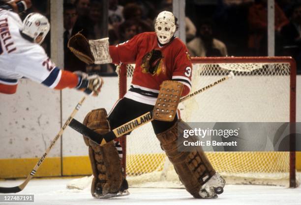 Goalie Tony Esposito of the Chicago Blackhawks looks to make the toe save on John Tonelli of the New York Islanders on November 20, 1982 at the...