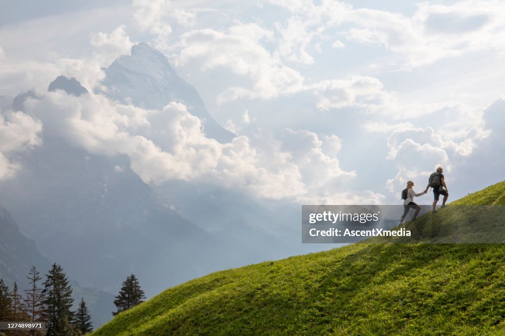 Vue aérienne du couple de randonnée traversant le pré alpin le matin