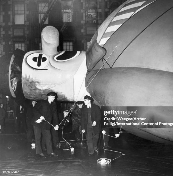 In preparation for the annual Macy's Thanksgiving Day parade, balloon handlers hold the ropes of the helium gas-filed Bobo the Hobo balloon filled,...