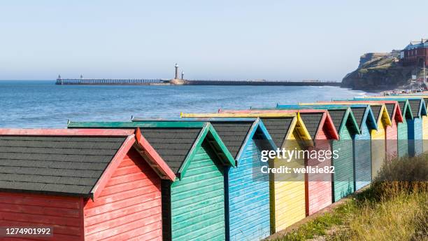 fading beach huts at whitby - shack stock pictures, royalty-free photos & images
