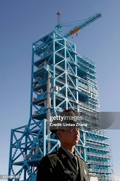 Chinese security stands near a Long March 2F rocket carrying Tiangong-1, China's first unmanned space module, stands at the Jiuquan Satellite Launch...