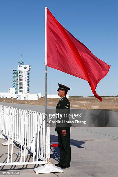 Chinese security stands near a Long March 2F rocket carrying Tiangong-1, China's first unmanned space module, stands at the Jiuquan Satellite Launch...