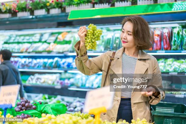 young asian women shopping in supermarket - asian woman shopping grocery stock pictures, royalty-free photos & images