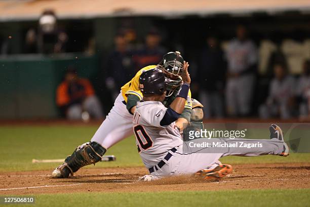 Landon Powell of the Oakland Athletics tags out Wilson Betemit of the Detroit Tigers out at home at the Oakland-Alameda County Coliseum on September...