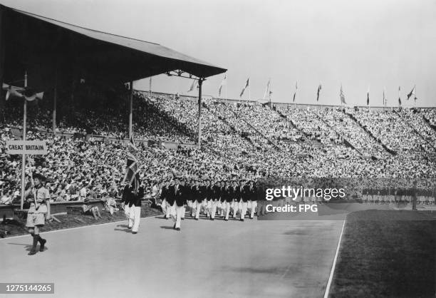 British fencer John Emrys Lloyd carrying the Union Jack as he leads the Great Britain Olympic team in the opening ceremony of the 1948 Summer...