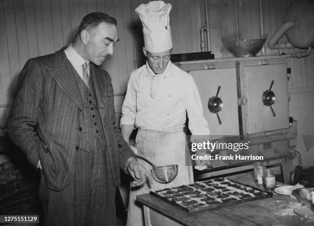 Camp commandant Captain A E Smith discussing catering details with chef J Brockie at a former army convalescent centre which will be home to Olympic...