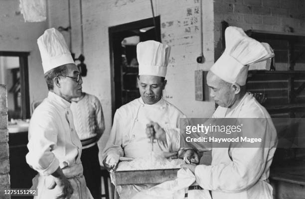 Three Korean chefs who have travelled with the Korean team attending the 1948 Summer Olympics to prepare food for their athletes, at the RAF camp in...