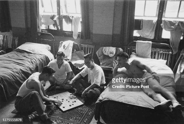 Male athletes of the Korean team relaxing with a board game in their accommodation at an RAF camp in Uxbridge, London, England, July 1948. Dubbed the...