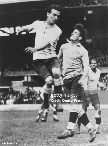 Argentine footballer Enrique Gainzarain leaps for the ball under pressure from Uruguayan footballer Jose Nasazzi whose Uruguay teammate Jose Leandro...