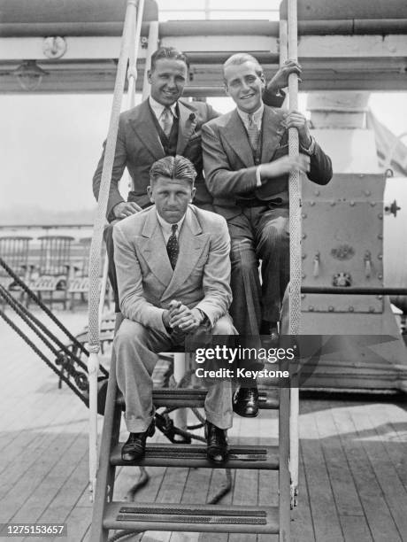 British rower Ted Phelps , his brother British rower Eric Phelps , and German rower Georg Von Opel sitting in the steps leading to an upper deck of...