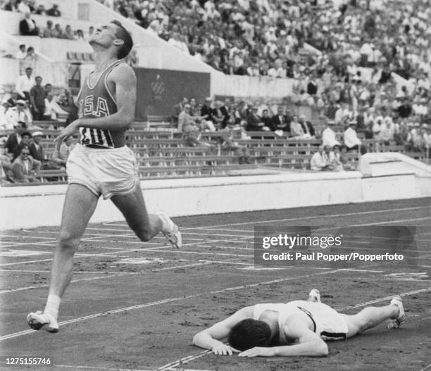 American athlete Earl Young in full stride as he finishes sixth, passing German athlete Carl Kaufmann who had collapsed shortly after finishing in...