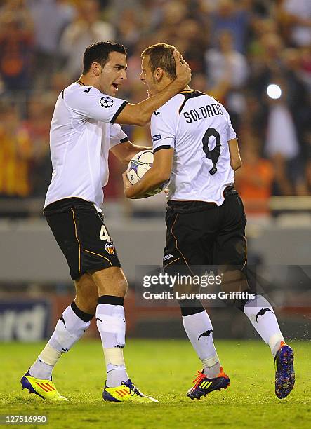 Roberto Soldado of Valencia celebrates scoring from the penalty spot with team mate Adil Rami during the UEFA Champions League Group E match between...