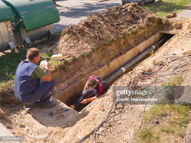 repairing underground district heating pipeline - trench town stock pictures, royalty-free photos & images