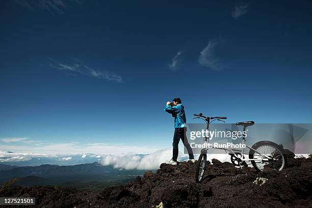 young man with mountain bike in the mountains - young woman standing against clear sky stock pictures, royalty-free photos & images