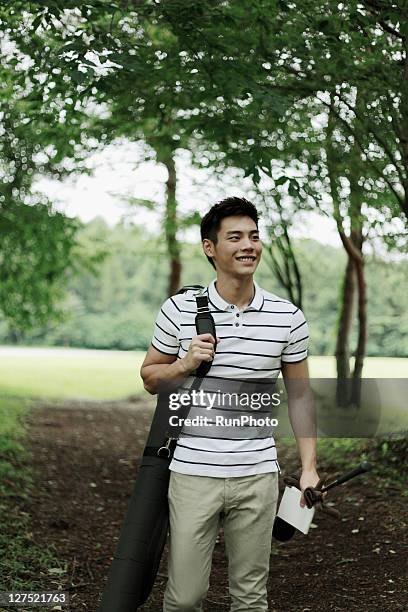 young man with golf club - adventure club stockfoto's en -beelden