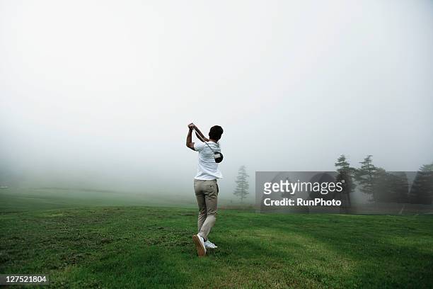 young man playing golf,back shot - golf swing from behind stock pictures, royalty-free photos & images