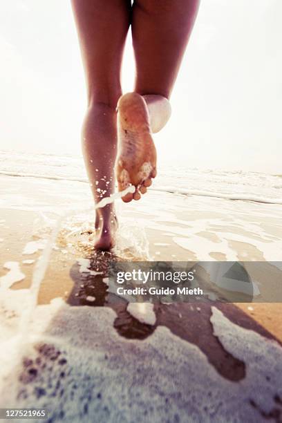 girl running on beach - barefoot soles female stock pictures, royalty-free photos & images