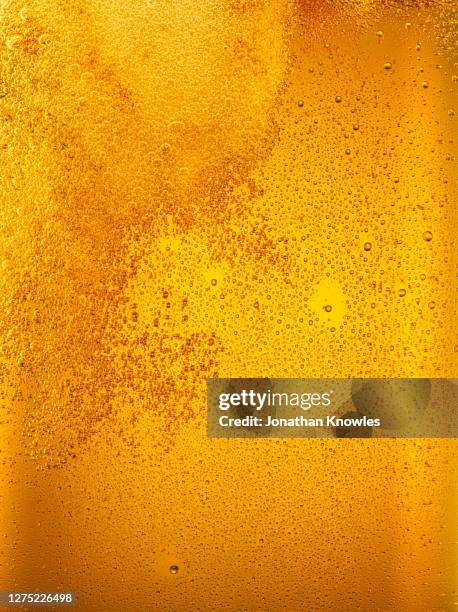 close up golden beer bubbles - bier stock-fotos und bilder