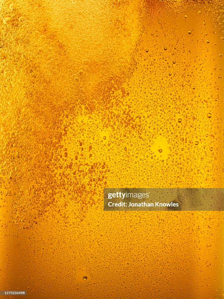 Close up golden beer bubbles