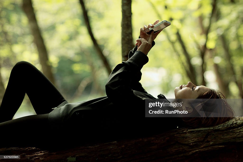 Woman touching the mobile phones in the mountains