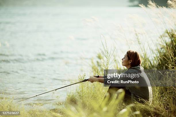 young woman fishing in the lake - fishing ストックフォトと画像