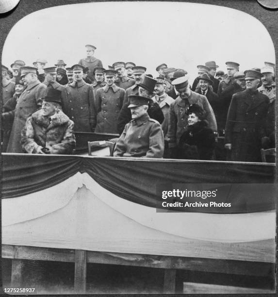 President Woodrow Wilson with his wife Edith , General Pershing and officers in the viewing stand at Chaumont, France, on Christmas Day 1918.