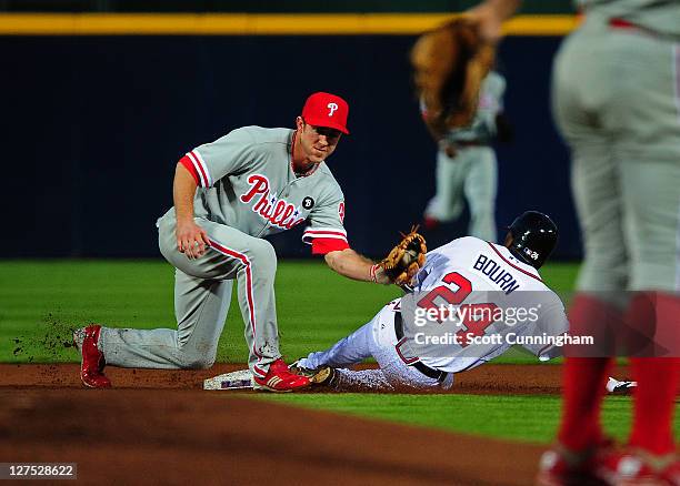 Michael Bourn of the Atlanta Braves steals second base against Chase Utley of the Philadelphia Phillies at Turner Field on September 28, 2011 in...