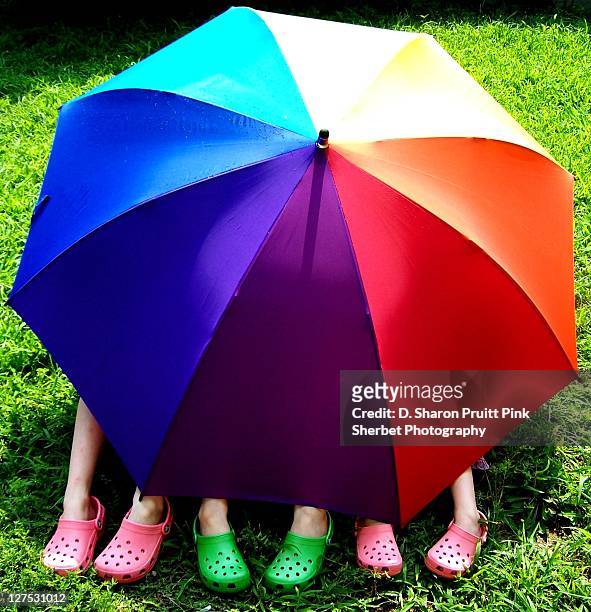 happy girls under rainbow umbrella - colorful shoes stock pictures, royalty-free photos & images