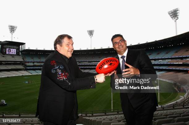 American performer Meat Loaf handballs to AFL Chief Executive Officer Andrew Demetriou during an AFL Grand Final entertainment press conference at...