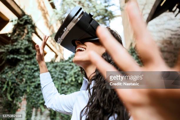 junge schöne frau genießen virtual reality-brille headset über grünen efeu hintergrund - vr goggles woman stock-fotos und bilder