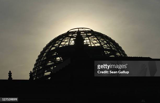 The sun rises over the cupola of the Reichstag, home of the Bundestag, on September 29, 2011 in Berlin, Germany. Bundestag members are scheduled to...