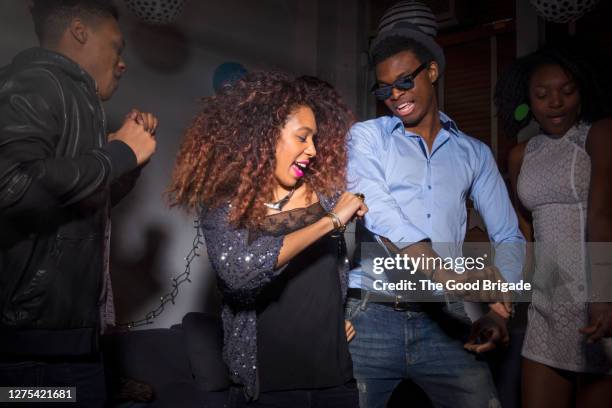 young man and woman dancing at house party - the party inside stock pictures, royalty-free photos & images