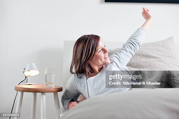 woman stretching in bed - morning bed stretch stock pictures, royalty-free photos & images