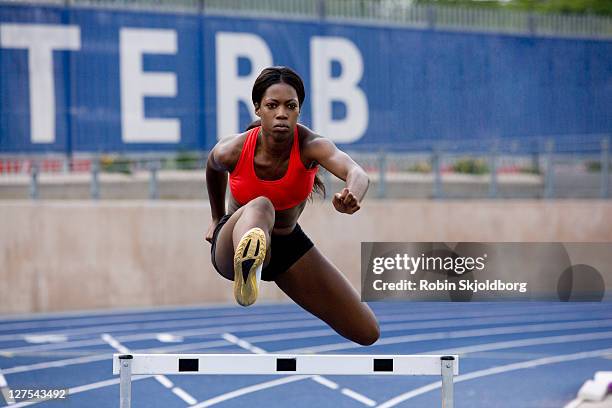 runner jumping over hurdles on track - häcklöpning löpgren bildbanksfoton och bilder