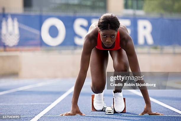 runner in start block on track - athlete stock pictures, royalty-free photos & images