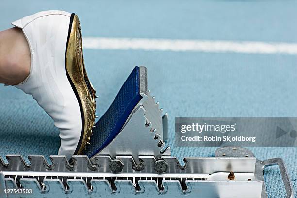 close up of spiked shoe at start block - spikskor för löpning bildbanksfoton och bilder