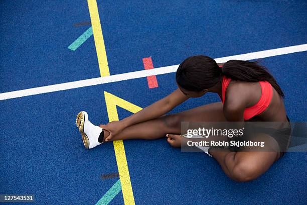 runner stretching on track - warm up exercise stockfoto's en -beelden