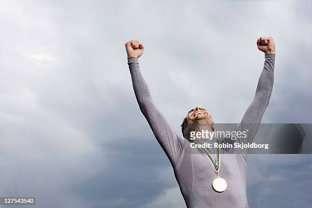 cheering runner wearing medal - sportsperson medal stock pictures, royalty-free photos & images