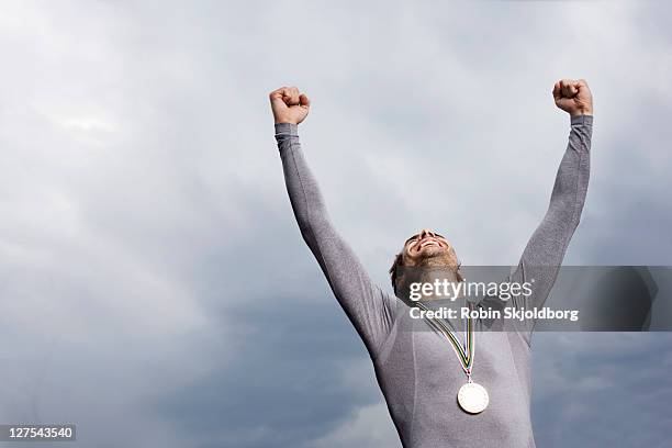 cheering runner wearing medal - medalha imagens e fotografias de stock