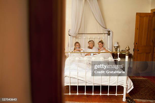 mother and daughters with coffee in bed - blonde hair roots stock pictures, royalty-free photos & images