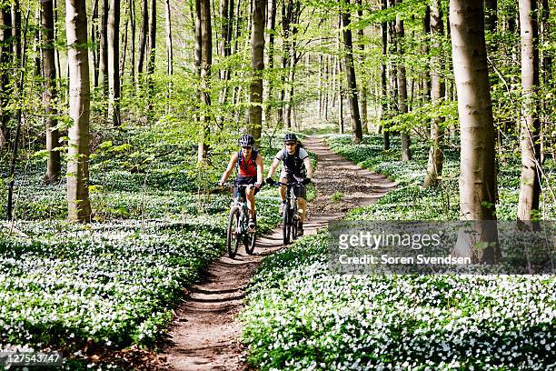 couple mountain biking together - springtime stockfoto's en -beelden