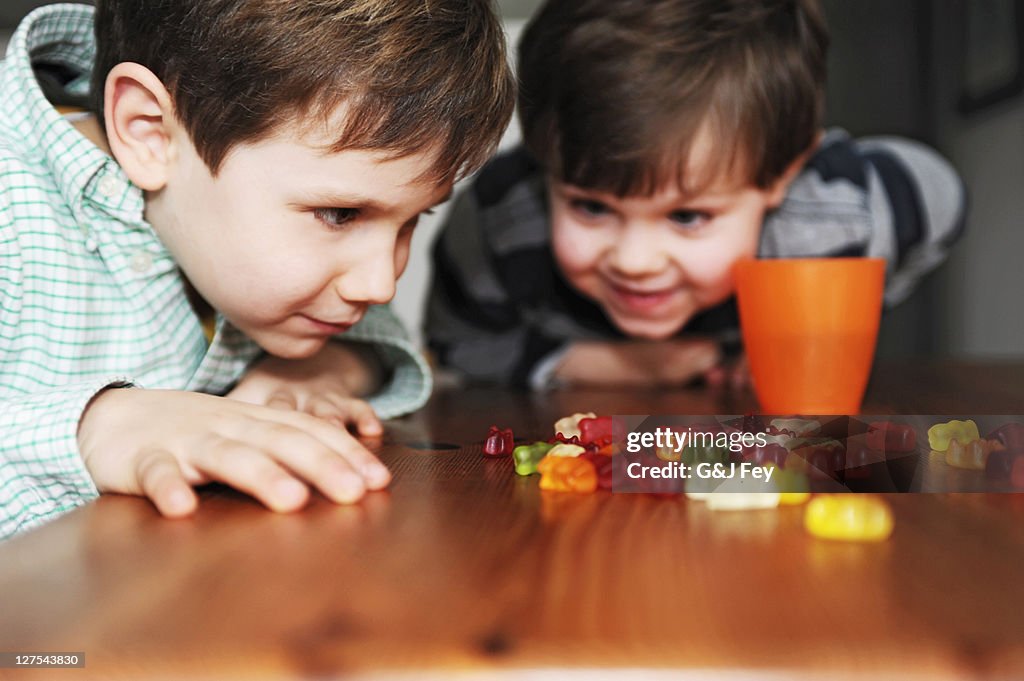 Boys playing with candy at table