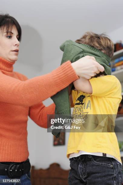 mother helping son get dressed - getting dressed stock pictures, royalty-free photos & images