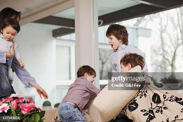 jungen spielen auf dem sofa - familie mit vier kindern stock-fotos und bilder