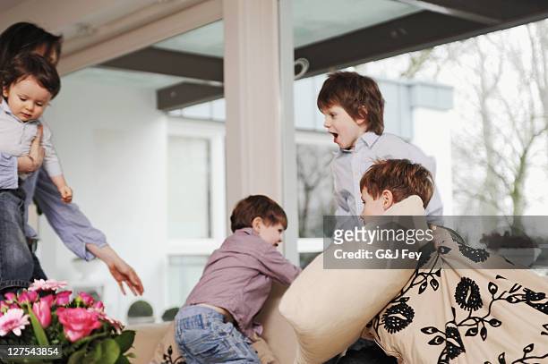 boys playing on the sofa - rough housing stock pictures, royalty-free photos & images
