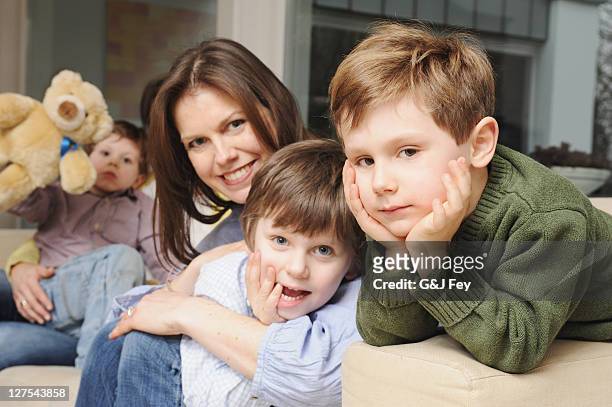 familie sitzt auf sofa zusammen - drei kinder stock-fotos und bilder