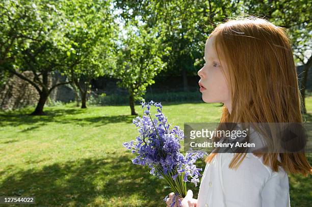 fille tenant des fleurs dans le jardin - cheveux roux photos et images de collection